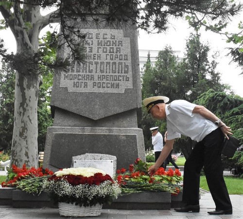 Представитель Российского фонда ветеранов в Севастополе капитан 1 ранга в отставке Фёдор Берсенев возлагает цветы к памятному знаку в честь основания города.