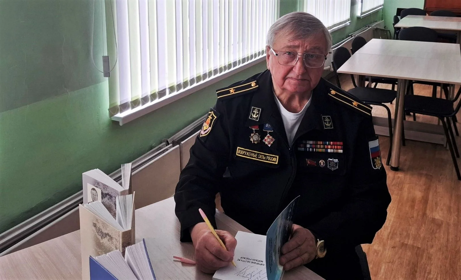 На снимке: представитель Российского фонда ветеранов в Кировской области капитан 3 ранга в отставке Юрий Малых подписывает читателям авторские экземпляры своей книги.