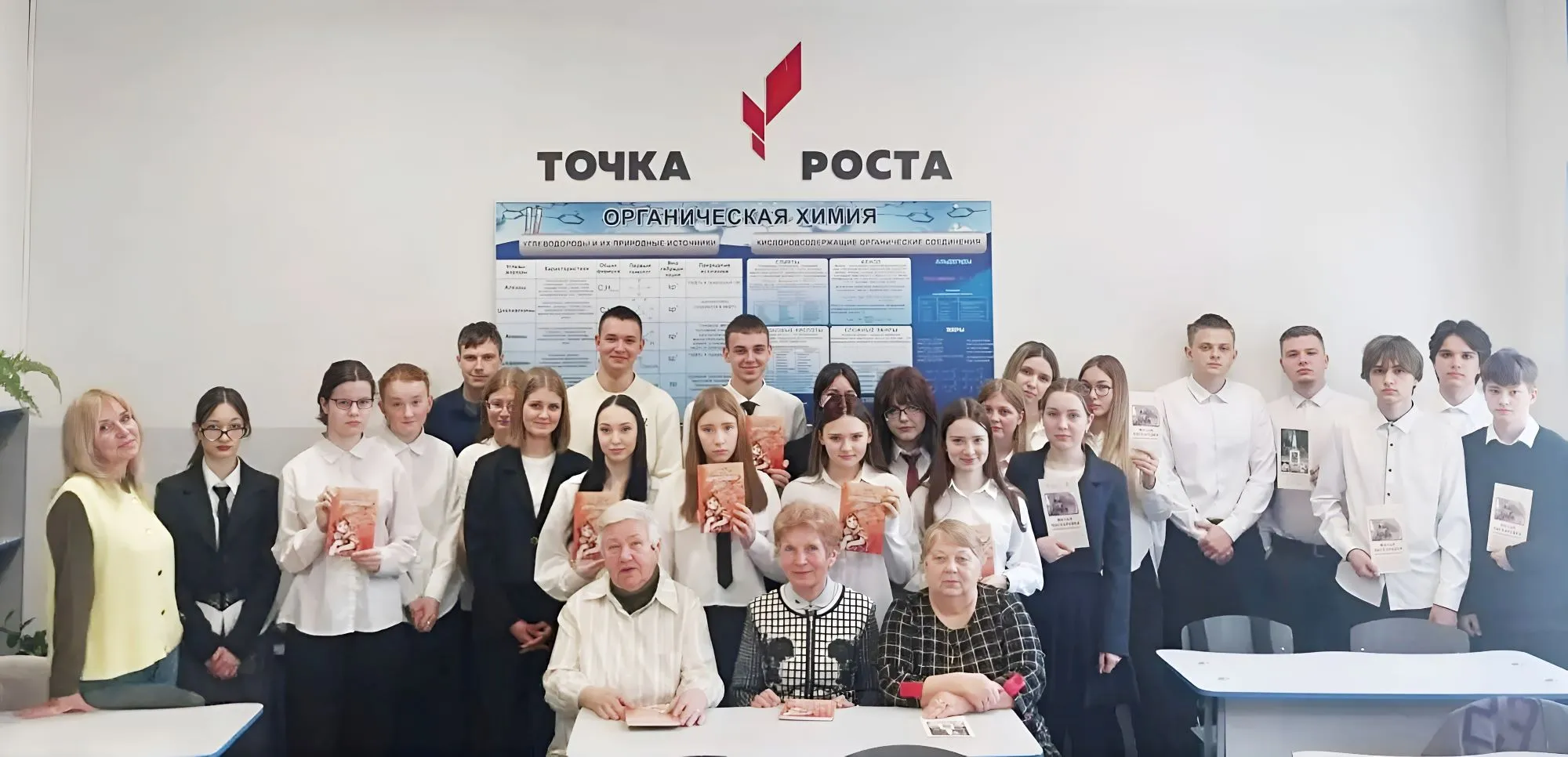 На снимке (слева направо сидят): председатель Совета ветеранов посёлка Боровёнка Елена Русакова, председатель Новгородского областного отделения Российского фонда ветеранов Нина Пилявская, Аделина Ковалевская, стоят учащиеся поселковой средней школы, слева – корреспондент Новгородского областного телевидения, автор будущего фильма Ирина Ускова.