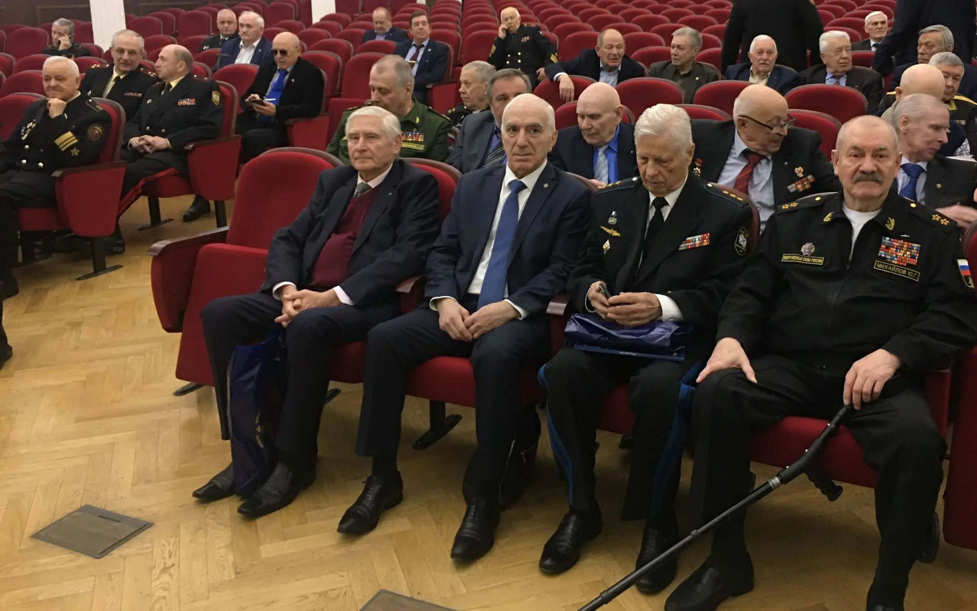 На снимке: в зале сидят (слева-направо) вице-адмирал Георгий Титаренко, контр-адмирал Левон Гарибян, генерал-полковник Владимир Дейнека, вице-адмирал Юрий Михайлов.
