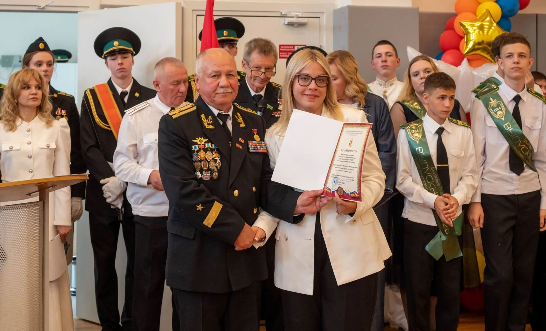  Член Правления Российского фонда ветеранов, советник председателя Фонда капитан 1 ранга в отставке Анатолий Свирякин вручает благодарность учительнице русского языка и литературы Анне Воробьёвой.
